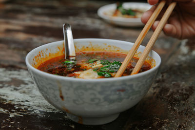 Close-up of hand holding soup in bowl