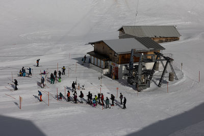 High angle view of people skiing on snow covered field