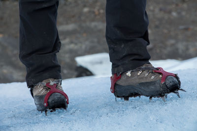 Low section of man standing on snow