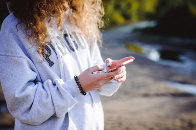 Midsection of woman using mobile phone