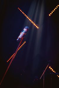 Low angle view of illuminated lighting equipment at night