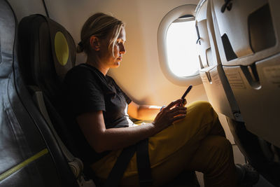 Side view of young woman sitting in bus