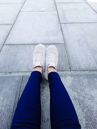 Low section of woman standing on footpath