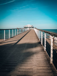 Pier over sea against blue sky