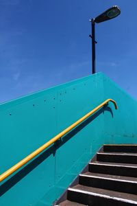 Low angle view of stairs against blue sky