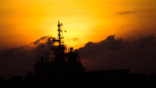 Silhouette ship by sea against sky during sunset