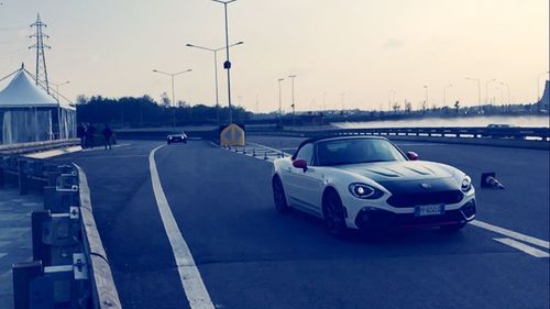 Cars on road against sky in city