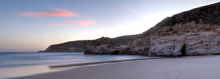 Scenic view of beach and mountains against sky