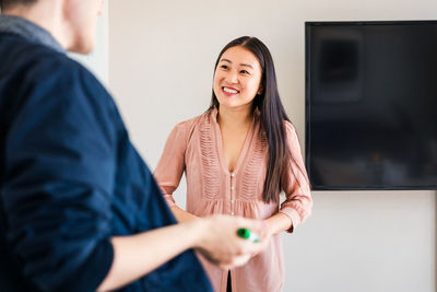 Smiling female entrepreneur discussing with colleague in board room