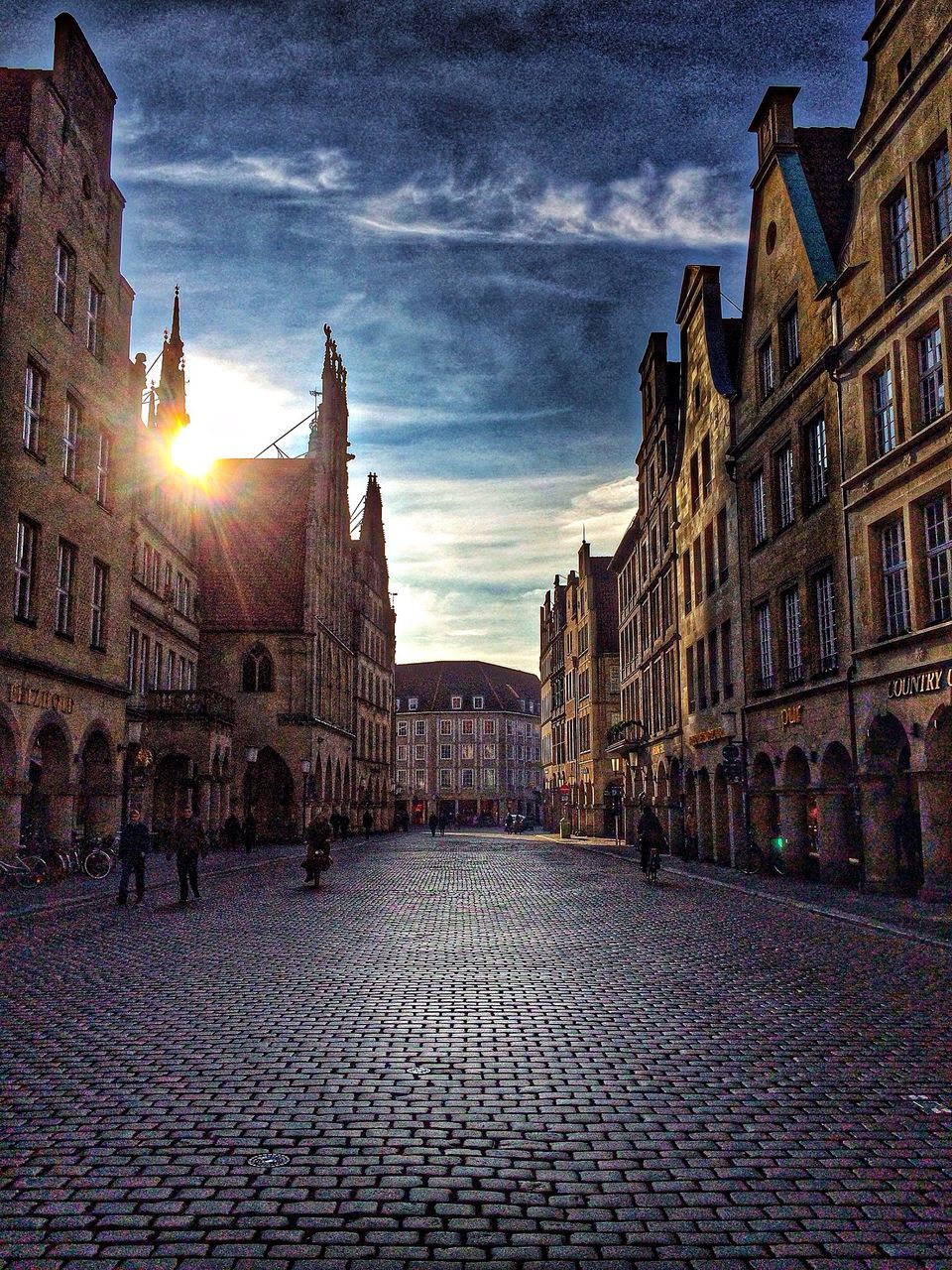 architecture, building exterior, built structure, cobblestone, sky, city, the way forward, street, building, residential building, old town, residential structure, sunlight, sunset, diminishing perspective, incidental people, outdoors, history, sun, lens flare
