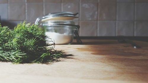 Close-up of herb and jar on table