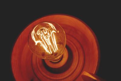 Close-up of illuminated lamp against black background