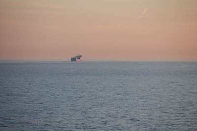 Commercial ship crossing the sea at sunset.