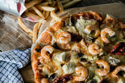 Directly above shot of pizza and french fries on table