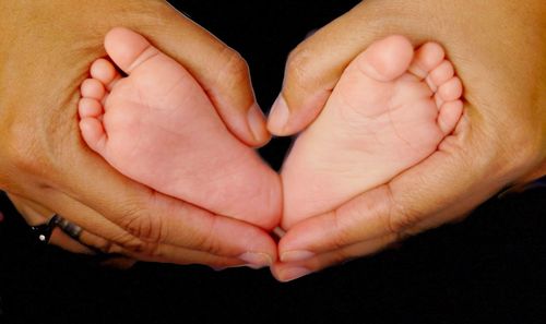 Close-up of father holding baby hand