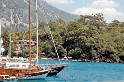 Boats in sea with mountain range in background