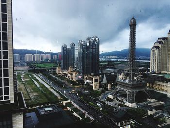 View of skyscrapers in city against cloudy sky