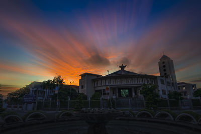 Low angle view of buildings against dramatic sky