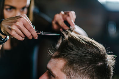 Hairdresser cutting man hair at salon