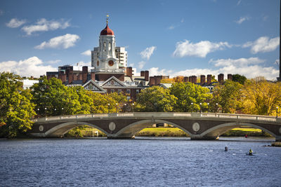 Arch bridge over river against buildings