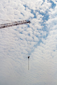 Low angle view of crane against sky