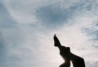 Low angle view of silhouette statue against sky