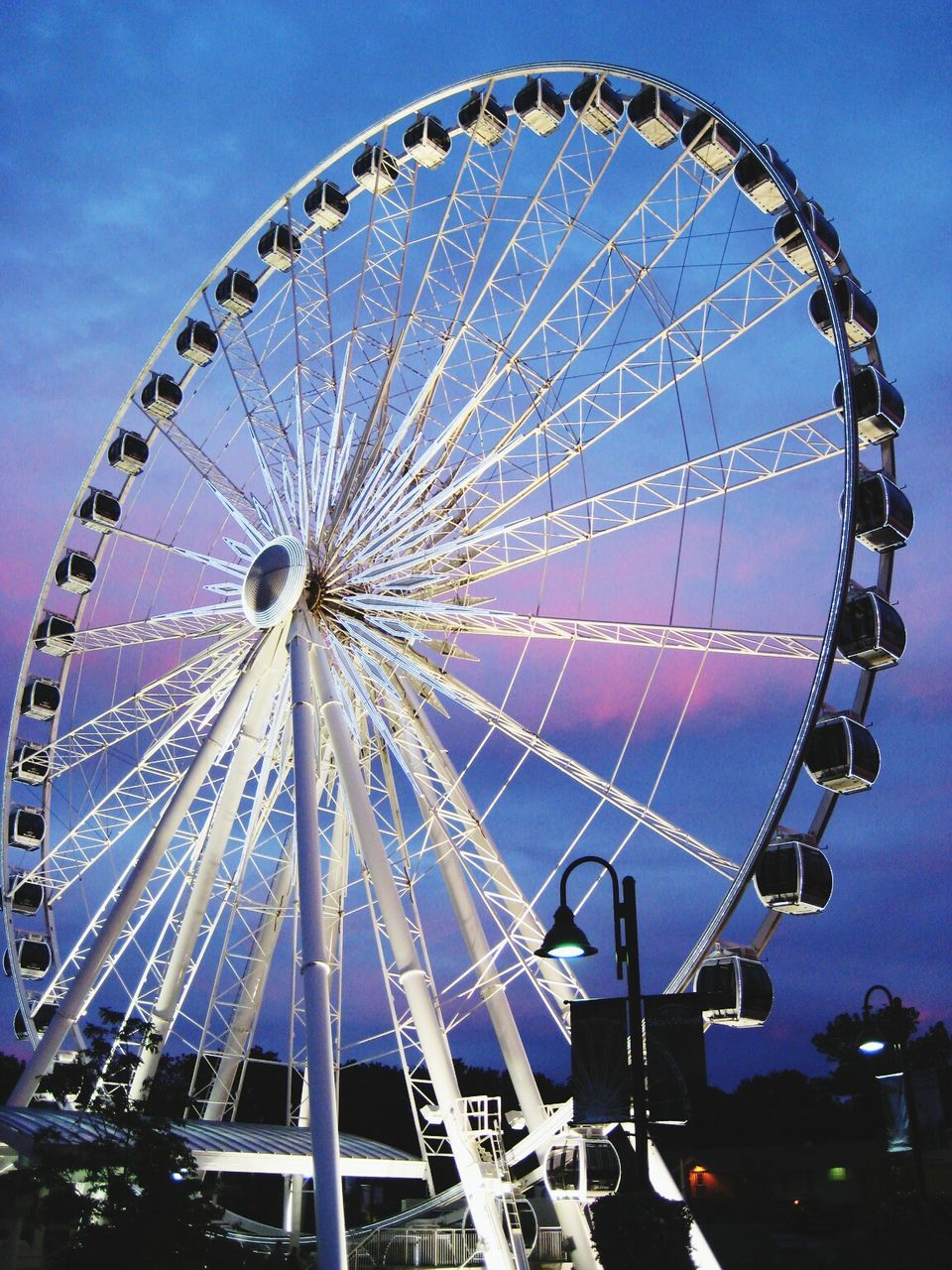 amusement park, amusement park ride, ferris wheel, arts culture and entertainment, low angle view, sky, fun, built structure, enjoyment, architecture, leisure activity, blue, fairground ride, big wheel, traveling carnival, large, travel destinations, outdoors, fairground, incidental people