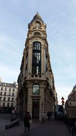 People in front of building against sky