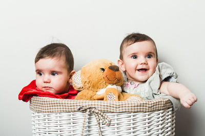Portrait of cute boy with toy against white background