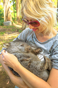 Smiling woman holding animal outdoors