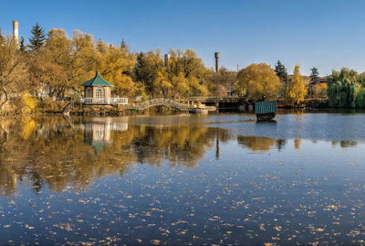 Sunny autumn evening on the blue lake with yellow trees. the ivanki village in ukraine