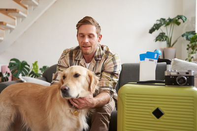 Portrait of young woman with dog at home