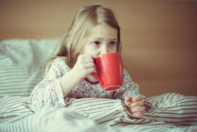 Portrait of a girl sitting on bed at home