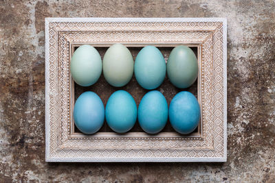 Happy easter rustic background with copy space. diy dyed various shades of blue easter eggs.