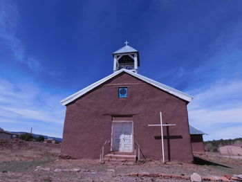 Low angle view of bell tower against blue sky