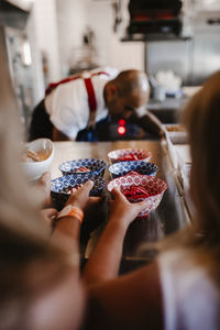 Girls reaching for dessert in restaurant kitchen