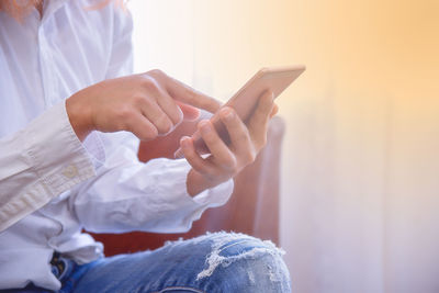 Midsection of man using mobile phone