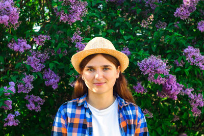 Beautiful young woman near blooming spring tree. bush lilac flowers. youth, love, fashion, romantic