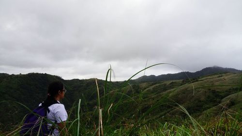 Boy on grass against sky