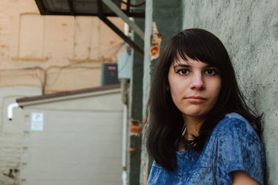 Portrait of young woman against wall