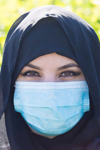 Close-up portrait of woman wearing hijab and mask