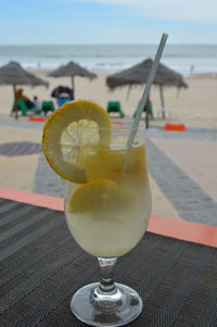 Close-up of drink on table at beach