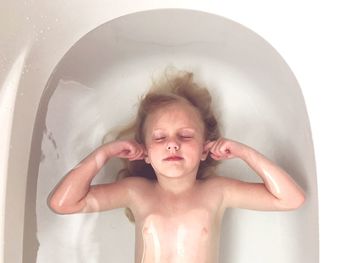 Cute young girl sleeping in bathtub