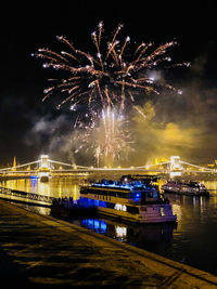 Firework display over river at night