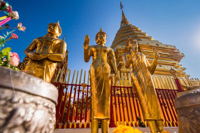 Low angle view of statue against building and sky