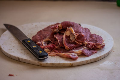 Close-up of meat and knife on cutting board
