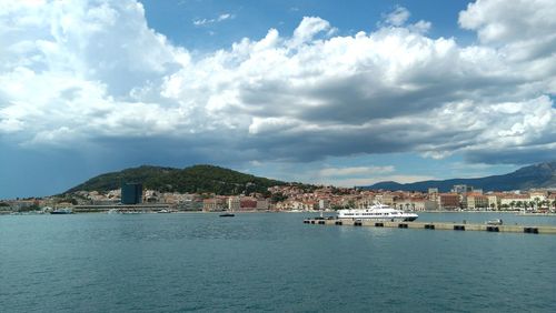 Scenic view of sea by buildings against sky