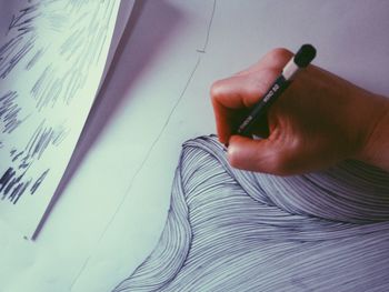 Cropped image of person drawing on paper