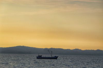 Silhouette sailboats in sea against sky during sunset