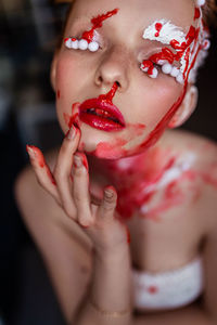 Portrait of a young girl in red and white paint